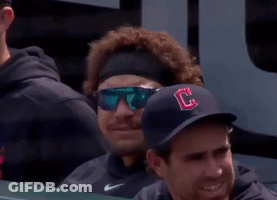 A Baseball Player Wearing Sunglasses And A Hat With The Letter C On It Blowing A Bubble GIF