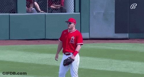 A Baseball Player Wearing Sunglasses And A Red Uniform Is Standing On The Field . GIF