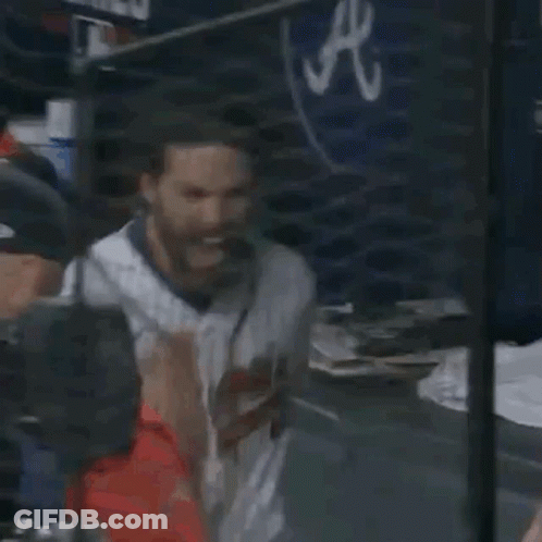 A Baseball Player With A Beard Is Sitting In The Dugout At A Game . GIF