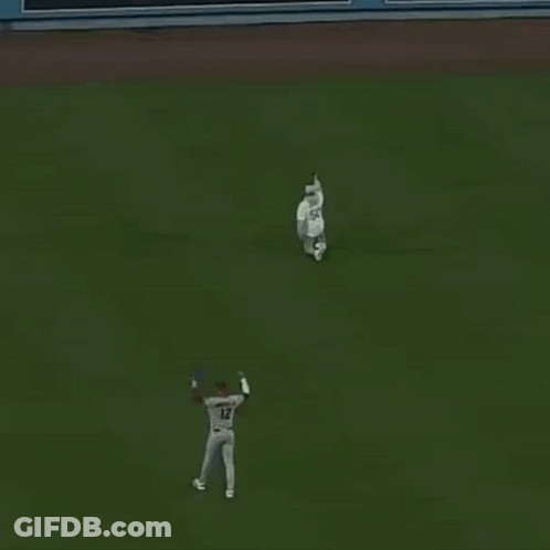 A Baseball Player With The Number 12 On His Jersey Stands On The Field GIF