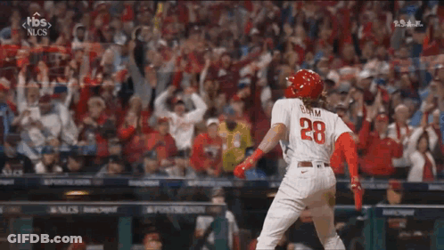A Baseball Player With The Number 28 On His Back Is Standing On The Field . GIF