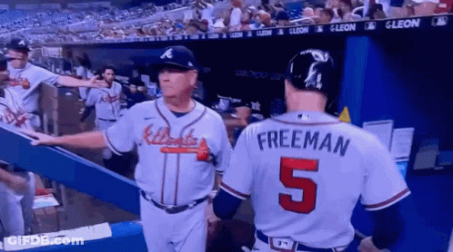 A Baseball Player With The Number 5 On His Back Talks To Another Player GIF