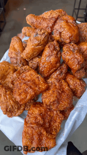 A Basket Of Fried Chicken Wings And Pieces Of Chicken GIF