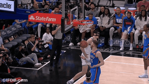 A Basketball Game Being Played In Front Of A State Farm Banner GIF