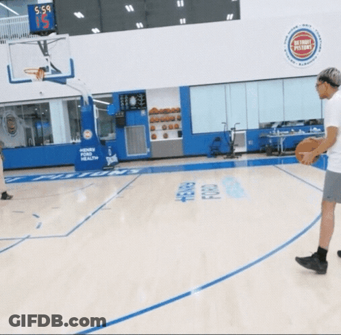 A Basketball Game Is Being Played In A Gym With A Scoreboard Above The Basketball Hoop That Says 5-5 GIF