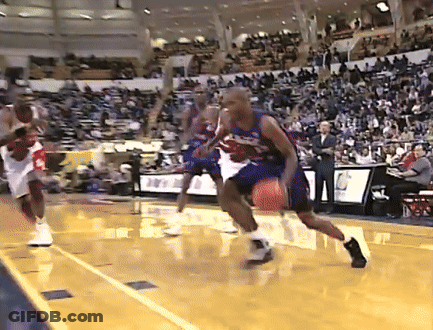 A Basketball Game Is Being Played In A Stadium With A Few People Watching GIF