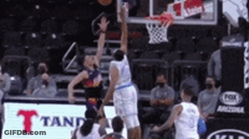 A Basketball Game Is Being Played In A Stadium With A Fox Ad In The Background . GIF