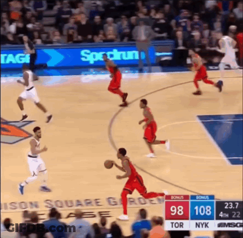 A Basketball Game Is Being Played In Front Of A Banner For Spectrum GIF