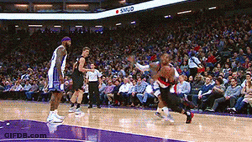 A Basketball Game Is Being Played In Front Of A Crowd And A Sign That Says Samud On It GIF