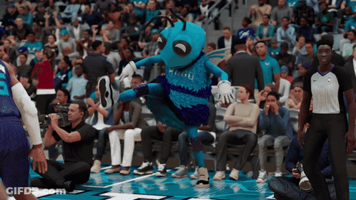 A Basketball Game Is Being Played In Front Of A Crowd And The Mascot For The Hornets Is Dancing GIF