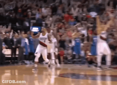 A Basketball Game Is Being Played In Front Of A Crowd That Is Cheering . GIF