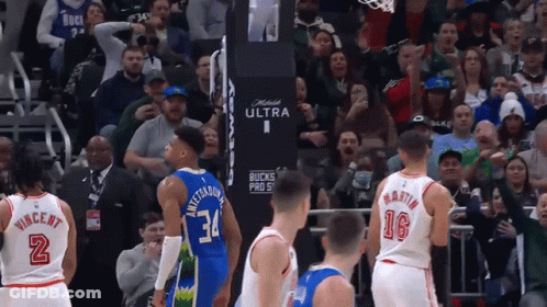 A Basketball Game Is Being Played In Front Of A Crowd That Is Cheering For The Bucks GIF