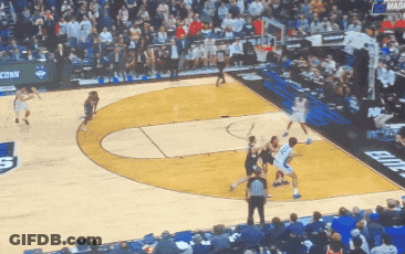 A Basketball Game Is Being Played In Front Of A Crowd With A Banner That Says Conn On It GIF
