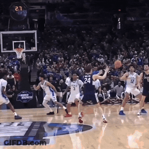 A Basketball Game Is Being Played In Front Of A Crowd With A Banner That Says Mercy Madness GIF