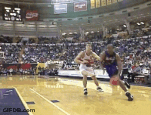 A Basketball Game Is Being Played In Front Of A Crowd With A Coca Cola Sign In The Background GIF