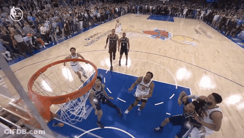 A Basketball Game Is Being Played In Front Of A Crowd With A New York Knicks Logo On The Court GIF