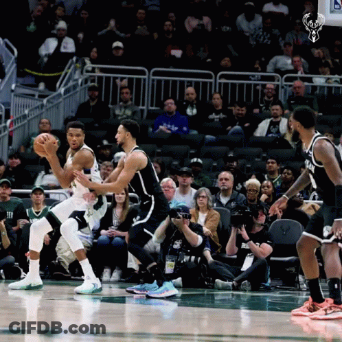 A Basketball Game Is Being Played In Front Of A Crowd With A Picture Of A Deer On The Scoreboard GIF