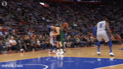 A Basketball Game Is Being Played On A Court With A Crowd In The Stands . GIF