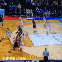 A Basketball Game Is Being Played On A Court With A Referee Watching GIF