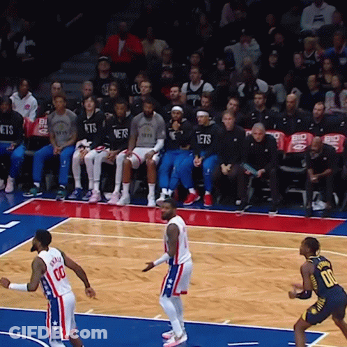 A Basketball Game Is Underway And The Nets Are Sitting In The Stands Watching GIF