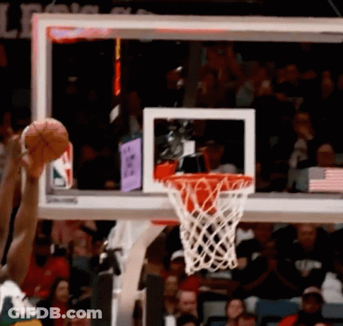 A Basketball Going Through A Hoop With A Crowd Behind It GIF