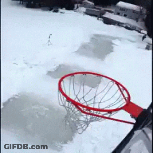 A Basketball Hoop Is Sitting In The Middle Of A Snow Covered Field GIF