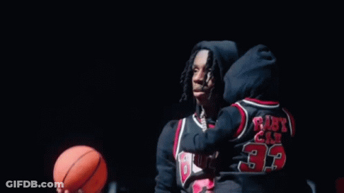 A Basketball Is Going Through A Basketball Hoop In A Gym . GIF