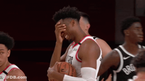A Basketball Player Covering His Face While Holding The Ball GIF