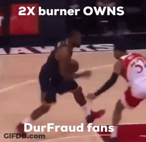 A Basketball Player Dribbles The Ball While Another Player Tries To Stop Him GIF