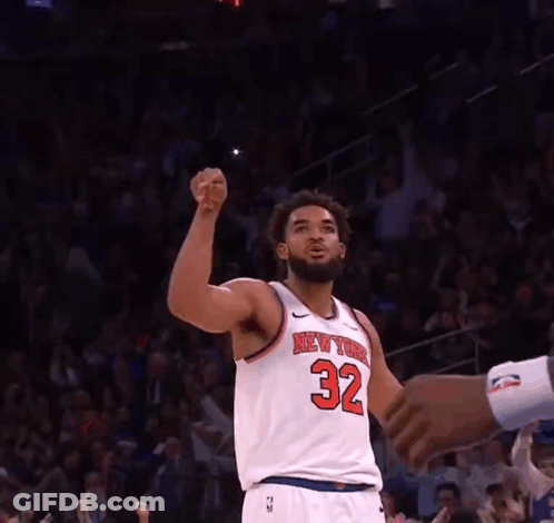 A Basketball Player For The New York Knicks Is Raising His Fist In The Air GIF