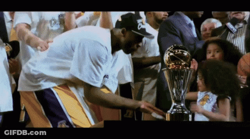 A Basketball Player Holds A Trophy In Front Of A Crowd GIF