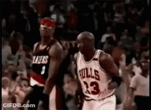 A Basketball Player In A Bulls Jersey Is Running Towards Another Player . GIF