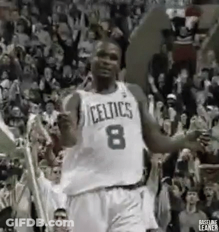 A Basketball Player In A Celtics Jersey Is Dancing In Front Of A Crowd Of People . GIF