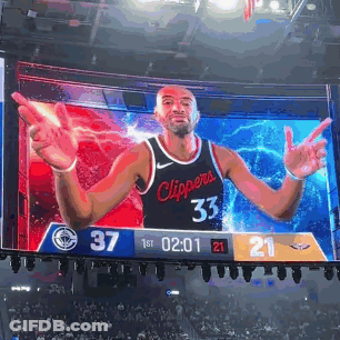 A Basketball Player In A Clippers Jersey Is On A Large Screen GIF