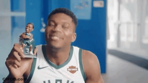A Basketball Player In A Harley Davidson Jersey Is Holding A Figurine GIF