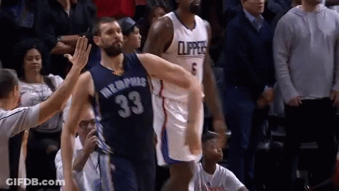 A Basketball Player In A Memphis Jersey Is Giving A High Five To Another Player . GIF