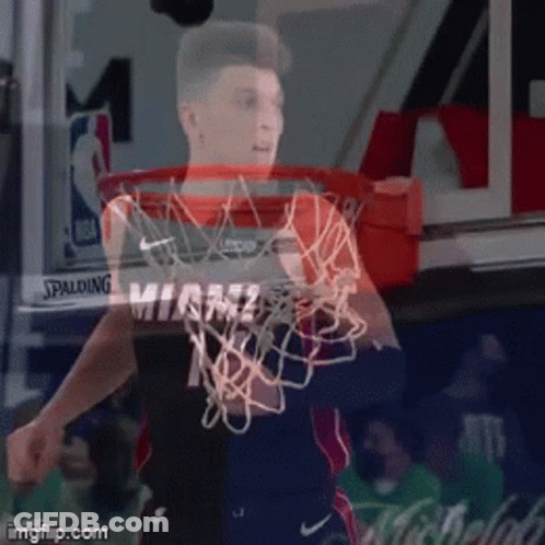 A Basketball Player In A Miami Jersey Is Holding A Basketball Net GIF