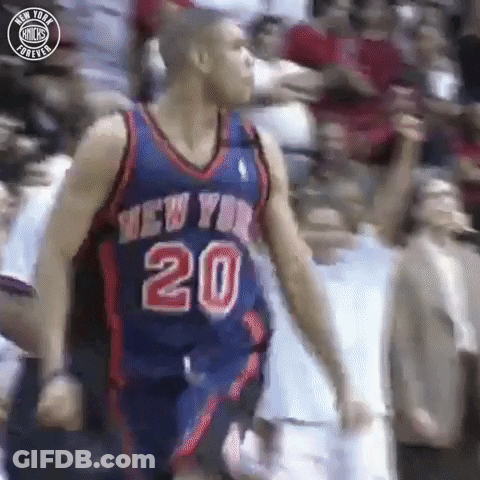 A Basketball Player In A New York Knicks Jersey Is Standing In Front Of A Crowd . GIF