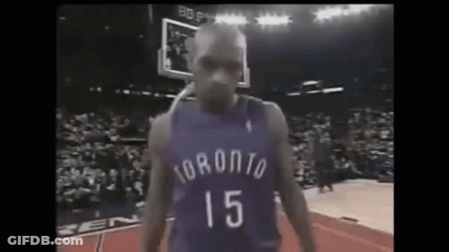 A Basketball Player In A Purple Jersey With The Number 15 On It Is Standing On A Court . GIF