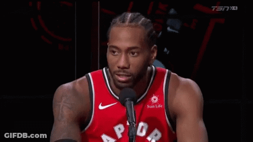 A Basketball Player In A Red Jersey Is Talking Into A Microphone . GIF