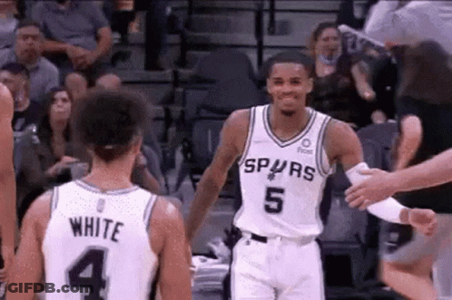 A Basketball Player In A Spurs Jersey Is Shaking Hands With Another Player . GIF