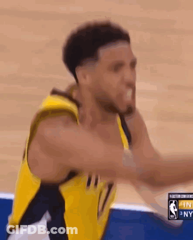 A Basketball Player In A Yellow Jersey Is Jumping In The Air While Playing Basketball . GIF