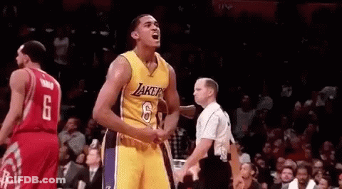 A Basketball Player In A Yellow Jersey Is Standing In Front Of A Referee . GIF