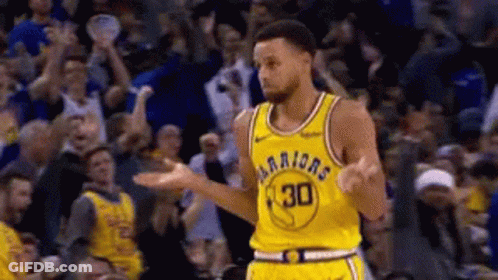 A Basketball Player In A Yellow Jersey With The Number 30 On It Is Standing In Front Of A Crowd Of People . GIF