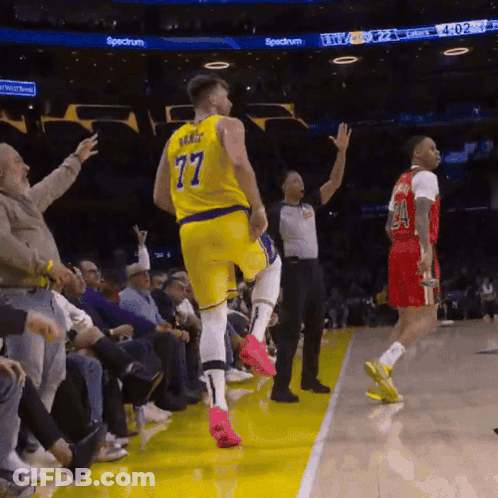 A Basketball Player In A Yellow Jersey With The Number 77 On The Back GIF