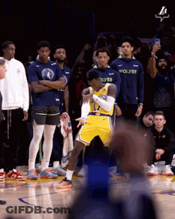 A Basketball Player In A Yellow Jersey With The Word Wolves On The Front GIF