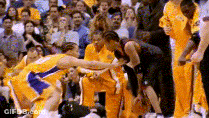 A Basketball Player Is Being Helped Off The Court By A Teammate While A Crowd Watches . GIF