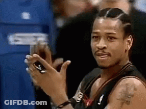 A Basketball Player Is Clapping His Hands While Looking At His Phone . GIF