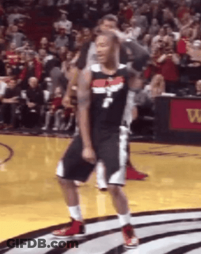 A Basketball Player Is Dancing On The Court In Front Of A Crowd During A Game . GIF