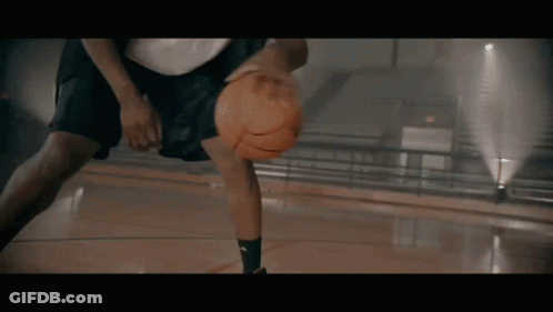 A Basketball Player Is Dribbling A Ball On A Court GIF